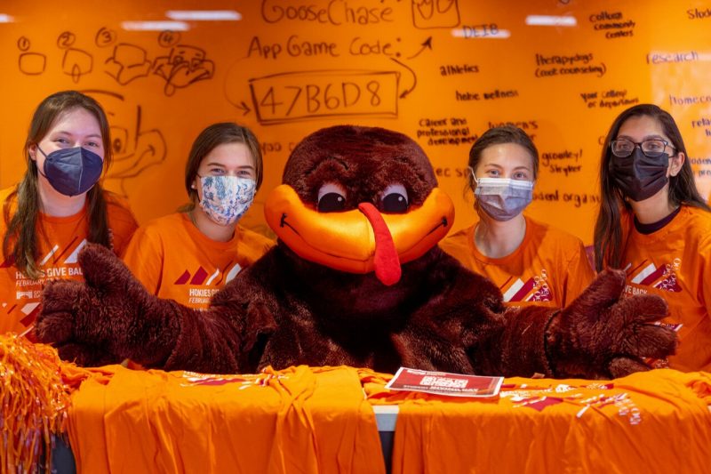 Virginia Tech student volunteers for Giving Day alongside the HokieBird in Squires Student Center on Feb. 23. 