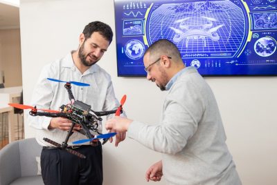 Two people looking at a drone