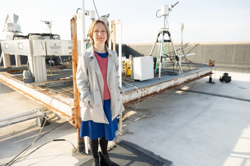 Professor Elena Lind standing on roof of Whittemore with air quality measuring instruments