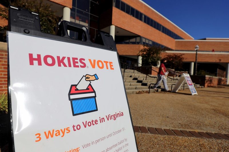 A sign in front of a brick student center building reads "Hokies Vote" and "3 ways to vote."