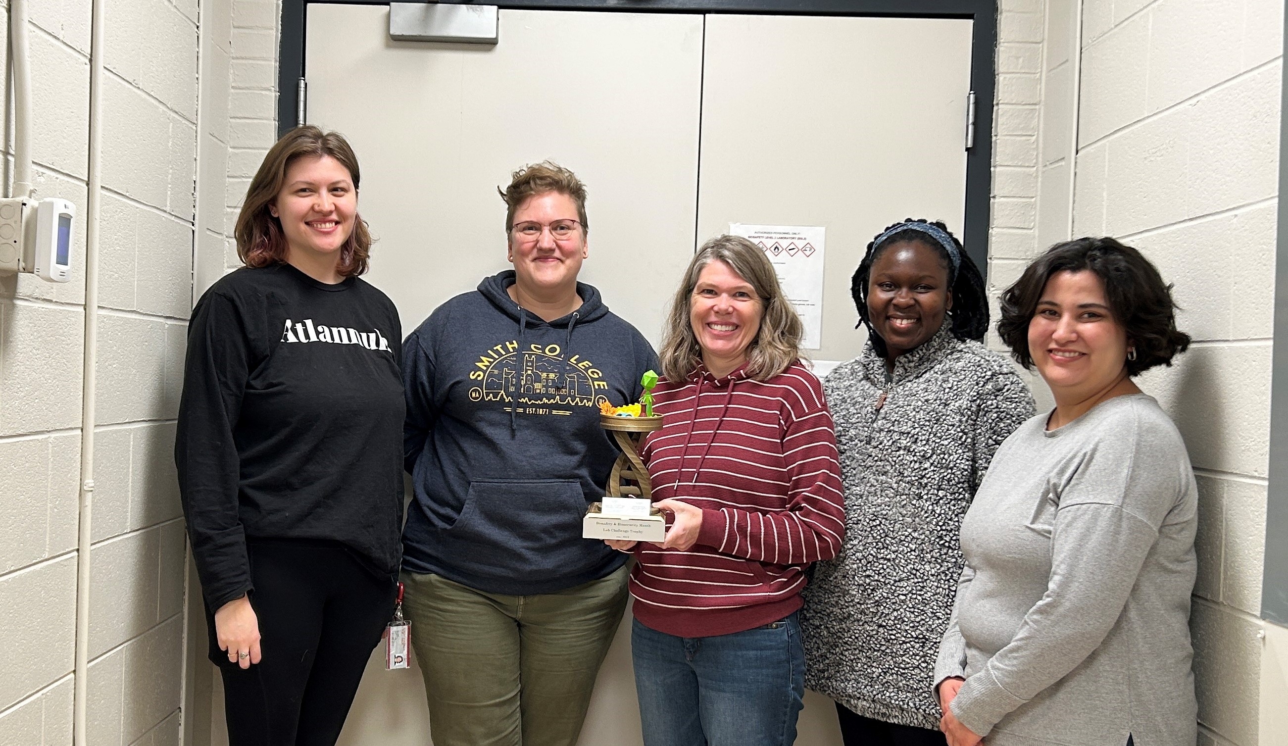 Nielsen Lab group and trophy Picture of the Nielsen Lab group holding the trophy. 5 team members are shown, with the 3rd person holding the trophy.