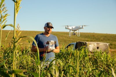 A man flying a drone in a field.