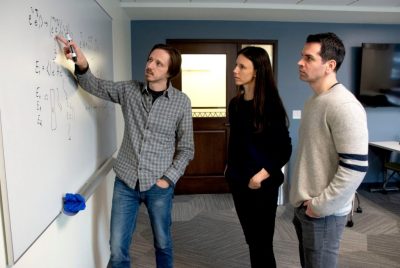 A group of researchers having discussion at a whiteboard.