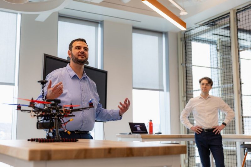 Walid Saad (at left), professor of electrical and computer engineering, and Alexander DeRieux, an electrical and computer engineering Ph.D. student, address media during a tour of Academic Building One on Feb. 25. Photo by Luke Hayes for Virginia Tech.